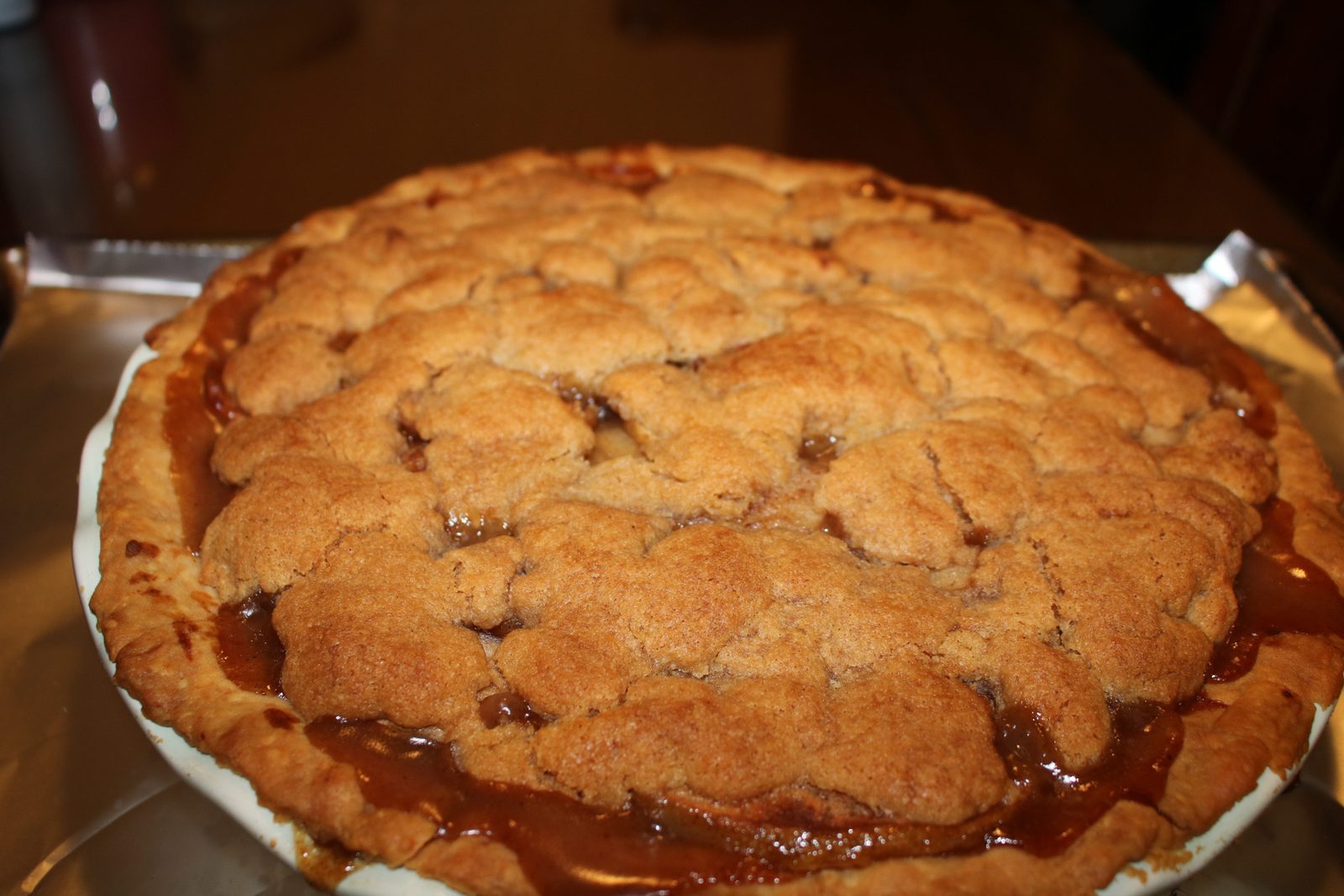 Apple crumble pie with caramel bubbling through the topping