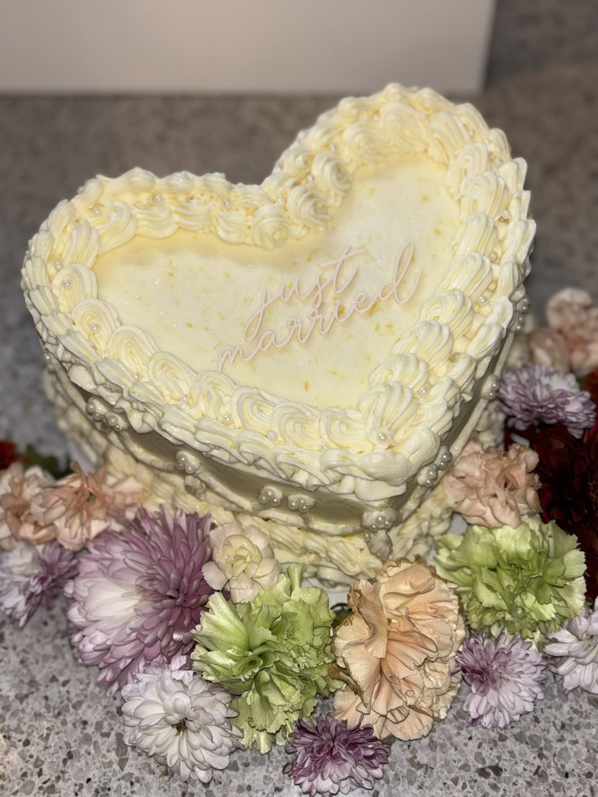 Heart-shaped Just Married cake with vintage piping and fresh flowers